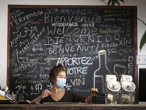 A waitress at local Chinese restaurant tallies up her receipts Sept. 30, 2020. Restaurants can only do delivery or takeout during the government-imposed red alert.