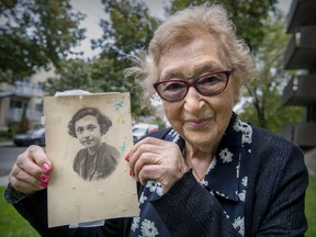 Holocaust survivor Muguette Myers with a photograph of herself as a 10-year-old girl wearing the yellow star on her sweater, identifying her as a Jew.