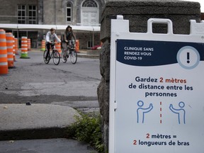 Two cyclists leave the Hotel-Dieu COVID-19 testing site in Montreal, on Oct. 1, 2020.