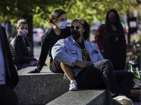 People listen to speakers  talking about police racism during a protest in Kent Park on Sunday, Oct. 4, 2020.