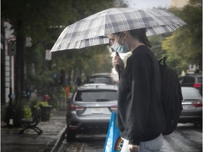 Woman with umbrella walks along St-Laurent Blvd. on October 7, 2020.