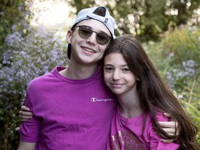 Tyler Frankel gets a hug from his little sister, Kylee, 11. The two are in isolation at home after their brother tested positive for COVID-19, although they both  tested negative.