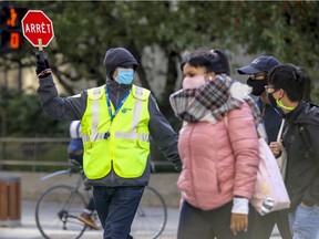 Crossing guard Daniel Garos wears a mask while working the intersection of Sherbrooke and University Sts. in Montreal Thursday October 8, 2020.