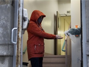 A woman gets her hands sprayed with disinfectant as she enters the Hotel-Dieu COVID-19 testing site in Montreal Oct. 7, 2020.