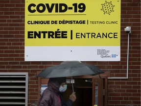 Masked pedestrians walk past a quiet COVID-19 testing site in Montreal Oct. 13, 2020. There was a steady trickle of clients, but no lineups at the centre.