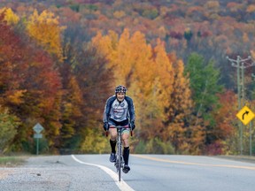 The fall colours provide a backdrop as Julio Tosques climbs a hill on Route 201 in Sainte-Marthe, west of Montreal Thursday October 15, 2020.