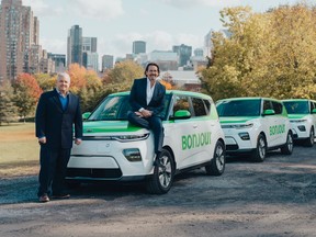 Téo Taxi CEO Frédéric Prégent and Taxelco owner Pierre Karl Péladeau pose in front of some of the company's electric cabs.