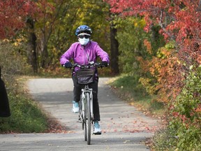 A woman is fully protected as she cycles around Visitation Nature park on Oct. 18, 2020