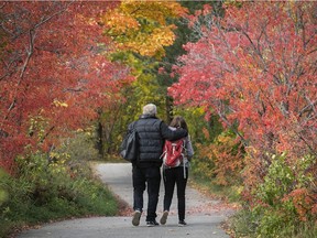 A couple enjoys the fall colours as they make their way around the paths at the Visitation Nature park on Sunday October 18, 2020 during the COVID-19 pandemic.