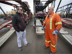 Richard Laberge, left, speaks with car hauler Wayne Leger at his transport company's yard in the Lachine borough of Montreal Tuesday October 20, 2020.  Snowbirds not heading south because of the coronavirus has had a serious impact on his car transport business.
