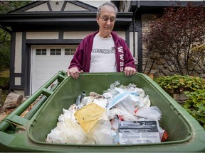 Jim Laberge with the garbage bin he hasn't put out since May 2019 at his home in Hudson. He has managed to drastically reduce his garbage output through recycling, reusing and composting.