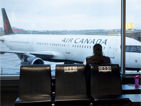 An airport security guard takes her break alone on a bank of seats marked with Covid-19 social distancing stickers at Pierre Elliott Trudeau International Airport in Montreal.