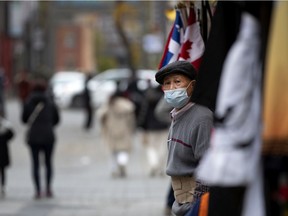 A merchant (who preferred not to have his name published for privacy reasons) looks out on to a near-empty street in Chinatown on Thursday.