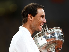 Rafael Nadal of Spain bites the winners trophy following victory in his Men's Singles Final against Novak Djokovic of Serbia on day fifteen of the 2020 French Open at Roland Garros on October 11, 2020 in Paris, France.