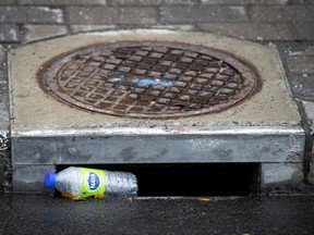 A single use water bottle is inches away from entering the storm drainage system in Montreal, on Monday, July 27, 2020.