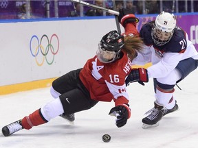 Canada's Jayna Hefford, left, battles with Team USA's Hilary Knight during the gold medal game at the Bolshoy Ice Dome during the Sochi Winter Olympics on Feb. 20, 2014.