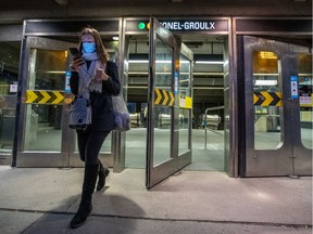 A mask-wearing commuter uses the Atwater entrance to the Lionel-Groulx Métro station on Oct. 22, 2020.