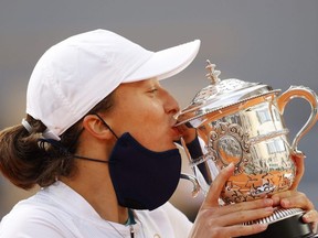 Iga Swiatek of Poland kisses the Suzanne-Lenglen Cup following victory in her Women's Singles Final against Sofia Kenin of the U.S. at the 2020 French Open at Roland Garros in Paris on Saturday, Oct. 10, 2020.