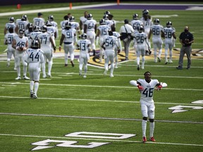 Joshua Kalu of the Tennessee Titans and his teammates take the field before the game against the Minnesota Vikings at U.S. Bank Stadium on Sept. 27, 2020, in Minneapolis.