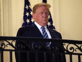 US President Donald Trump looks out from the Truman Balcony upon his return to the White House from Walter Reed Medical Center, where he underwent treatment for Covid-19, in Washington, DC, on October 5, 2020.