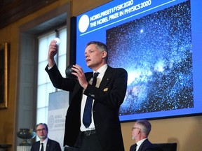 Ulf Danielsson (C), member of the Royal Swedish Academy of Sciences, speaks during the announcement of the winners of the 2020 Nobel Prize in Physics during a news conference at the Royal Swedish Academy of Sciences, in Stockholm, Sweden, on October 6, 2020. - Roger Penrose of Britain, Reinhard Genzel of Germany and Andrea Ghez of the US won the Nobel Physics Prize for their research into black holes, the Nobel jury said.