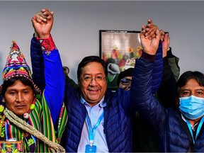 Bolivia's leftist presidential candidate Luis Arce (C), of the Movement for Socialism party, celebrates with running mate David Choquehuanca (R) early on October 19, 2020, in La Paz, Bolivia. - Bolivian presidential candidate Luis Arce, the leftist heir to former leader Evo Morales, appeared headed to a first-round election victory on October 18, 2020 with 52.4 percent of the vote, according to an authoritative exit poll from TV station Unitel.