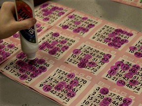 A woman marks her numbers as she plays bingo.
