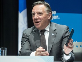 Quebec Premier François Legault installs the COVID Alert app on his phone as he speaks to the media during the COVID-19 press briefing Monday, Oct. 5, 2020 in Montreal.