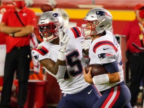 New England Patriots quarterback Jarrett Stidham (4) celebrates a touchdown with wide receiver N'Keal Harry (15) against the Kansas City Chiefs during the fourth quarter of a NFL game at Arrowhead Stadium.