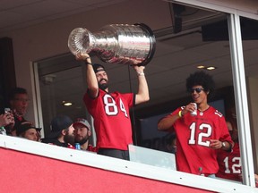 Tampa Bay Lightning player Alex Killorn hoists the Stanley Cup in the first quarter of a NFL game between the Los Angeles Chargers and the Tampa Bay Buccaneers at Raymond James Stadium in Tampa, Fla., on Sunday.