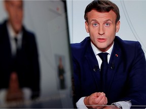 French President Emmanuel Macron is seen on screens as he addresses the nation about the state of the COVID-19 outbreak in France in this illustration picture from Oct. 28, 2020.