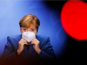 German Chancellor Angela Merkel puts on her face mask at the end of a news conference with Bavarian Prime Minister Markus Soeder and Berlin's mayor Michael Mueller (not pictured) at the Chancellery in Berlin, Germany October 28, 2020. REUTERS/Fabrizio Bensch/Pool     TPX IMAGES OF THE DAY