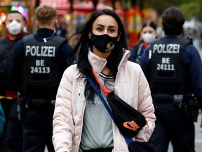 Police officers check the people wearing face masks at Wilmersdorfer Strasse shopping street, as the coronavirus disease (COVID-19) outbreak continues, in Berlin, Germany, October 26, 2020. REUTERS/Fabrizio Bensch