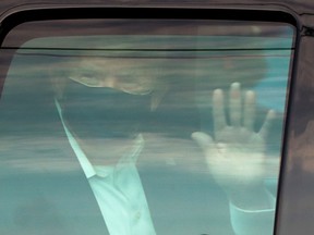 U.S. President Donald Trump waves to supporters as he briefly rides by in the presidential motorcade in front of Walter Reed National Military Medical Center, where he is being treated for coronavirus disease (COVID-19) in Bethesda, Maryland, on Sunday, Oct. 4, 2020.