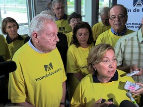 Clifford Lincoln (left) and Baie-D'Urfé Mayor Maria Tutino (right, speaking), and other West Island mayors arrive at a press briefing to discuss the future of the Train de l'Ouest project in 2014.