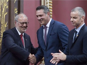 Quebec Liberal MNA Enrico Ciccone, centre, is congratulated by Quebec Liberal Opposition Leader Pierre Arcand, left, and applauded by Michel Bonsaint, secretary general of the National Assembly, after he was sworn in as member of the National Assembly on Oct. 15, 2018, in Quebec City.
