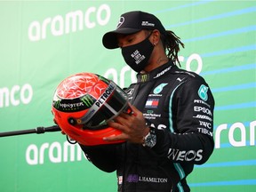 Mercedes' Lewis Hamilton celebrates with a red helmet after winning the race
