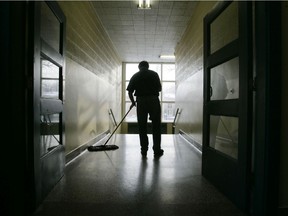 A man cleans the hallway of a Quebec school.