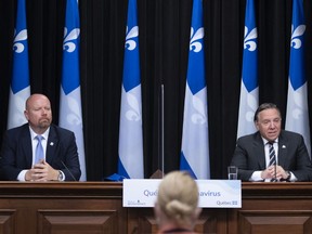 Premier François Legault, right speaks as Quebec Indigenous Affairs Minister Ian Lafrenière, left, looks on, at a news conference after he was sworn in, Friday, October 9, 2020 at the legislature in Quebec City. Lafrenière replaces Sylvie D'Amours.