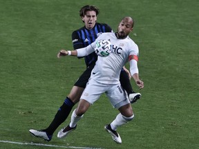 Montreal Impact defender Luis Binks, rear, battles New England Revolution forward Teal Bunbury during the first half at Red Bull Arena in Harrison, N.J., on Oct. 14, 2020.