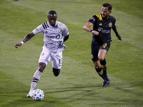 Montreal Impact defender Zachary Brault-Guillard (15) glides past Columbus Crew midfielder Artur (8) during the first half at MAPFRE Stadium. The Crew lost their first home game in 12 contests by the score of 2-1.