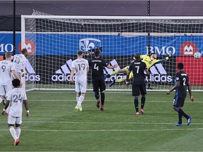 Revolution forward Teal Bunbury (10) heads the ball for a goal past Impact goalkeeper James Pantemis during the first half at Red Bull Arena Wednesday night.