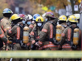 Montreal firemen wear a COVID-19 face masks while responding to a house fire in the Ville Emard district of Montreal, on Wednesday, October 21, 2020.