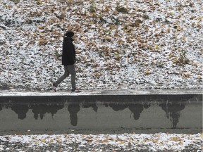A man walks along a path at Lafontaine park that received its first dusting of snow on Nov. 3, 2020.