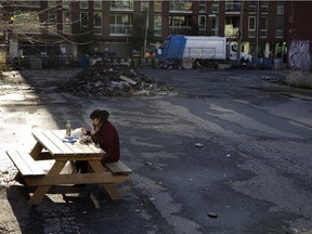 A pandemic lunch for one. Caroline Hateau eats her lunch alone in a vacant lot in the Griffintown district of Montreal, on Wednesday, November 4, 2020.