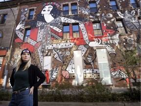 Mural artist Ola Volo poses in front of one of her works, Keep Walking, in Montreal.
