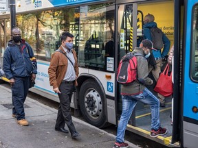 Montrealers wearing masks board a bus on Thursday November 5, 2020.
