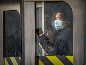 A masked transit user pushes through the doors at the Guy-Concordia Metro station in Montreal Monday November 9, 2020.