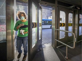 A masked transit user pushes through the doors at the Guy-Concordia métro station on Nov. 9, 2020.