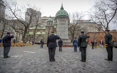 Representatives from the Royal Canadian Legion and the Canadian military stay physically distanced during a scaled-down Remembrance Day ceremony at the Cenotaph in Montreal's Place du Canada in 2020.
